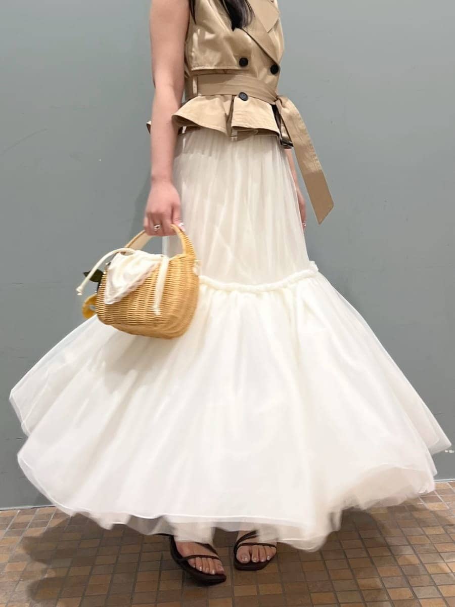 ベージュ系のワンピース、ホワイト系のかごバッグ、ブラウン系のサンダルを着用したレディースの夏コーディネートの5枚目の写真