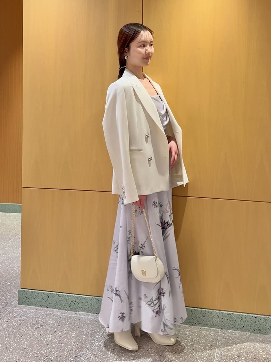 ホワイト系のテーラードジャケット、パープル系のワンピース、ホワイト系のショルダーバッグを着用したレディースの春コーディネートの2枚目の写真