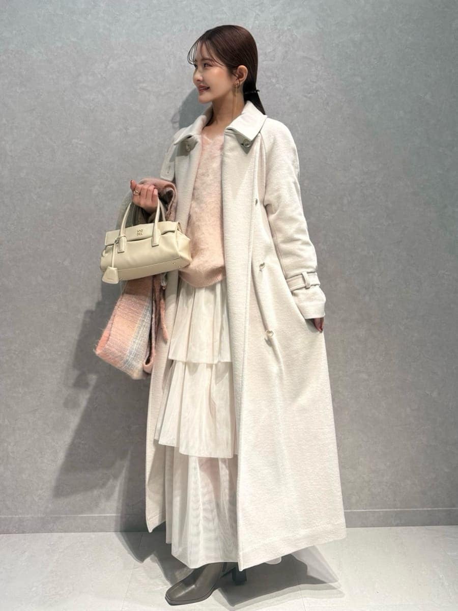 ピンク系のニット/セーター、ホワイト系のチェスターコート、ホワイト系のスカートを着用したレディースの冬コーディネートの3枚目の写真