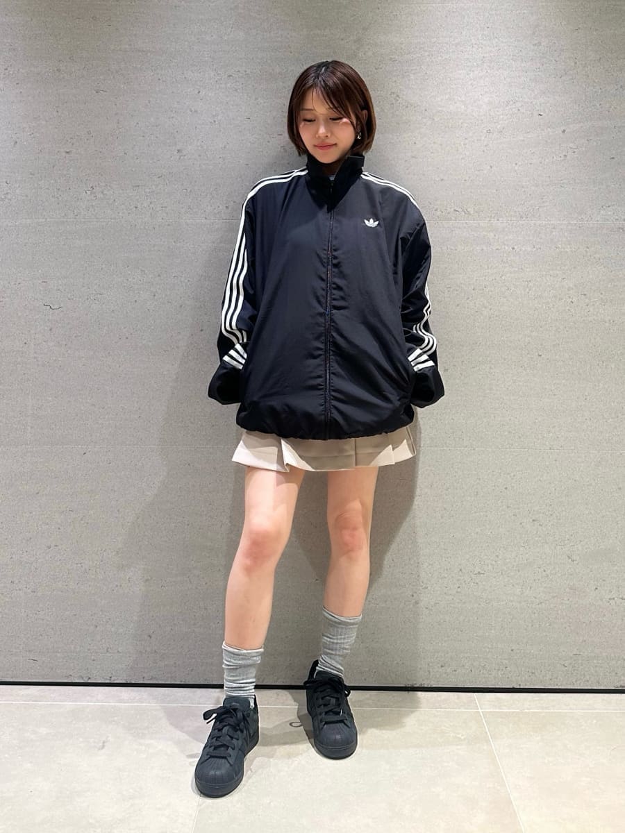 ベージュ系のスカート、ブラック系のブルゾン、ブラック系のスニーカーを着用したレディースの冬コーディネートの2枚目の写真