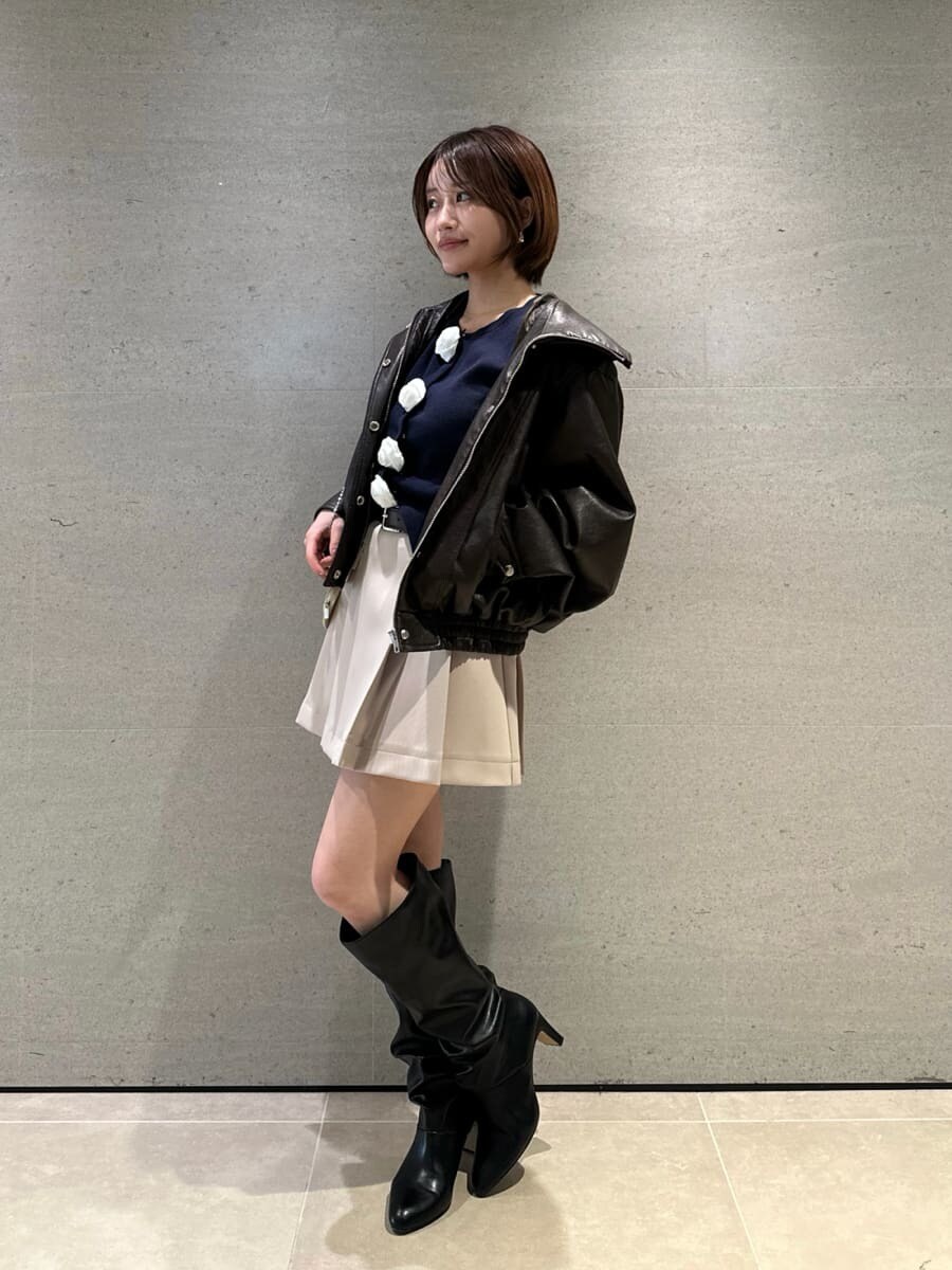 ブラック系のブーツ、ブラウン系のブルゾン、ベージュ系のスカートを着用したレディースの冬コーディネートの4枚目の写真