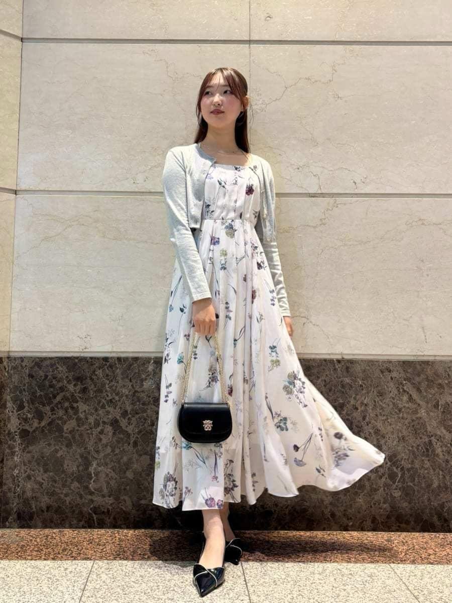 ホワイト系のワンピース、ブラック系のパンプス、ブラック系のショルダーバッグを着用したレディースの冬コーディネートの2枚目の写真