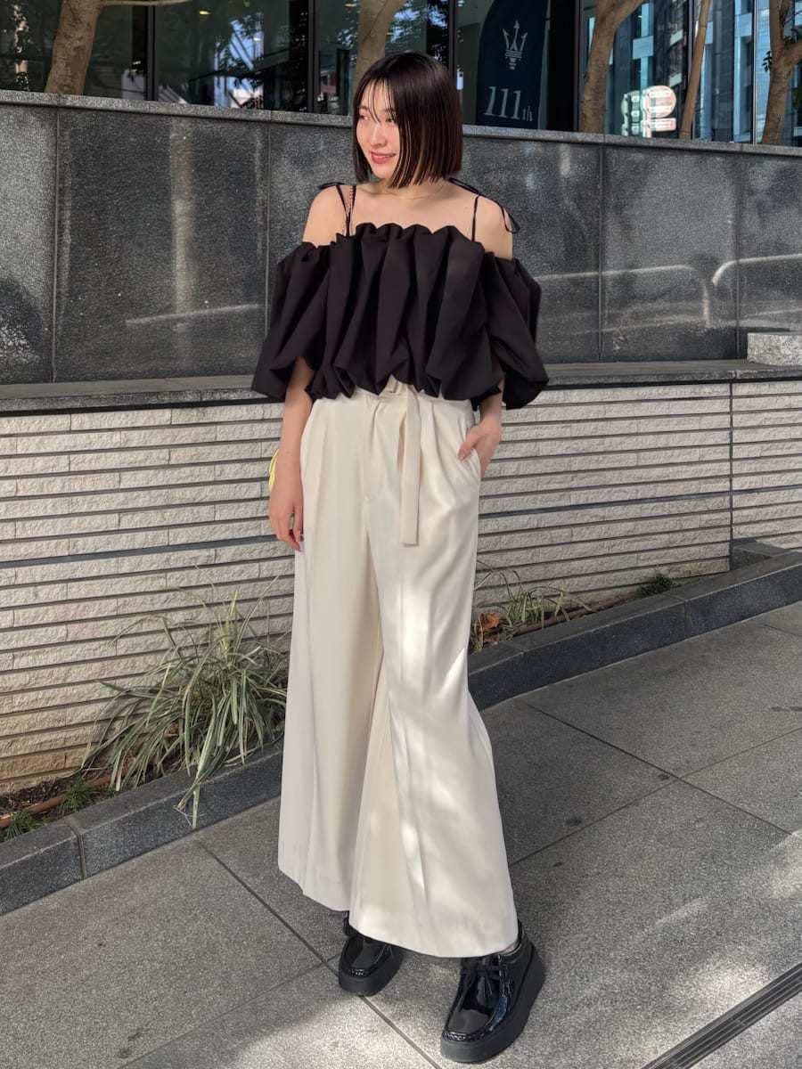 ホワイト系のその他パンツ、ブラック系のシャツ/ブラウス、イエロー系のショルダーバッグを着用したレディースの冬コーディネートの2枚目の写真