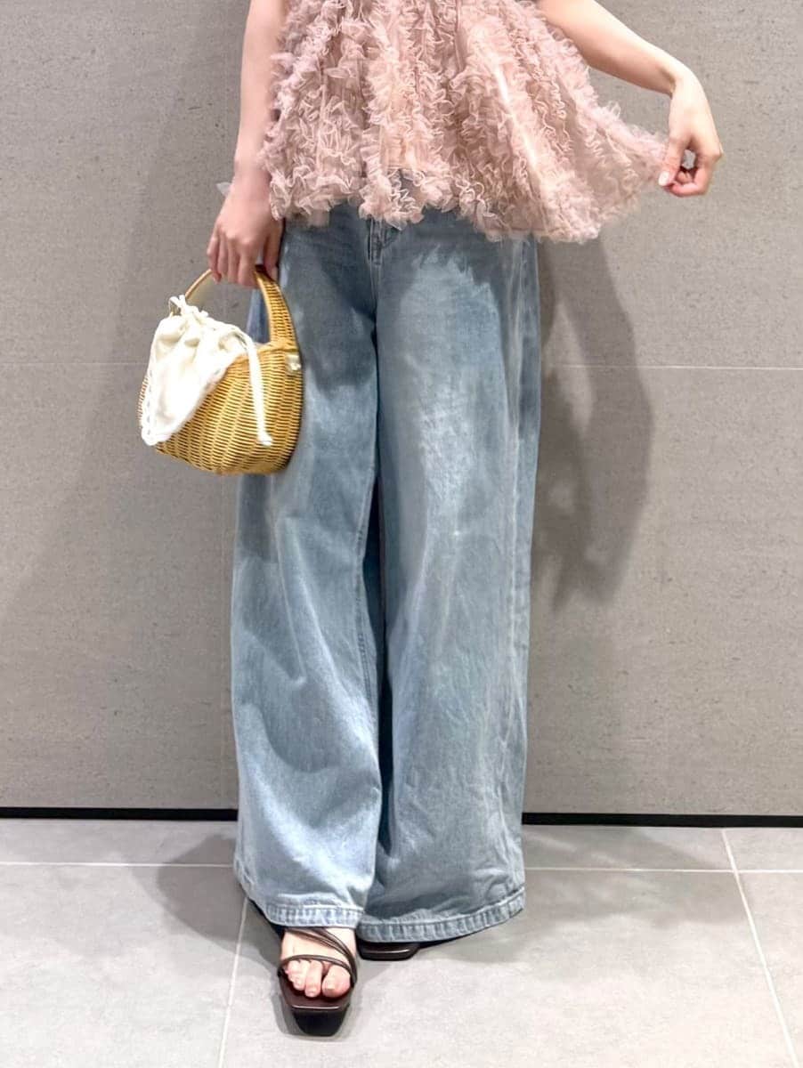 ホワイト系のかごバッグ、ブルー系のデニムパンツ、ブラウン系のサンダルを着用したレディースの夏コーディネートの5枚目の写真