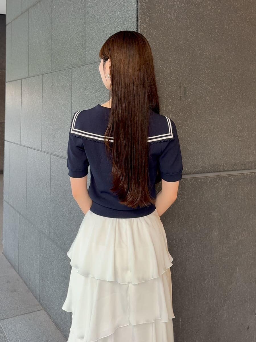 ホワイト系のかごバッグ、ホワイト系のスカート、ブルー系のニット/セーターを着用したレディースの夏コーディネートの6枚目の写真