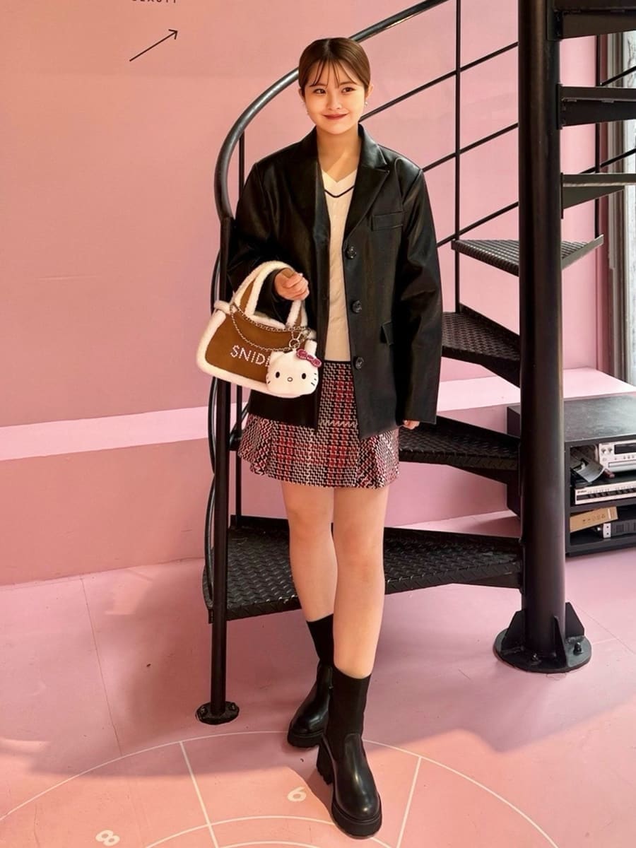 ブラック系のテーラードジャケット、ホワイト系のニット/セーター、レッド系のスカートを着用したレディースの秋コーディネートの3枚目の写真