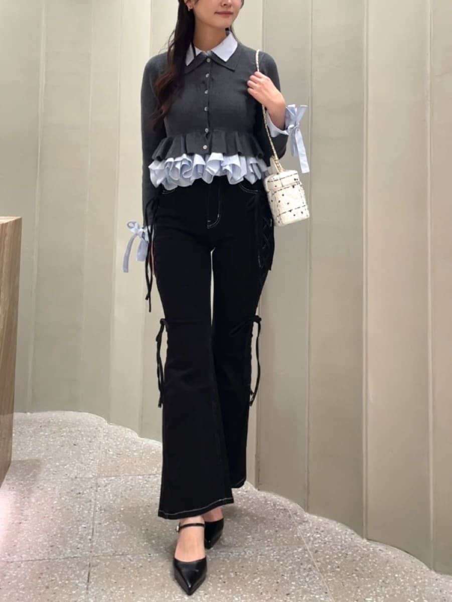 ブラック系のデニムパンツ、グレー系のカーディガン/ボレロ、ブラック系のパンプスを着用したレディースの秋コーディネートの5枚目の写真