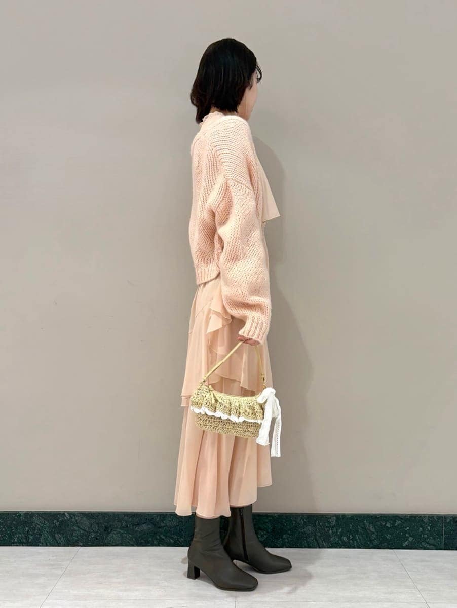 ピンク系のワンピース、ピンク系のカーディガン/ボレロ、ゴールド系のイヤリングを着用したレディースの冬コーディネートの4枚目の写真