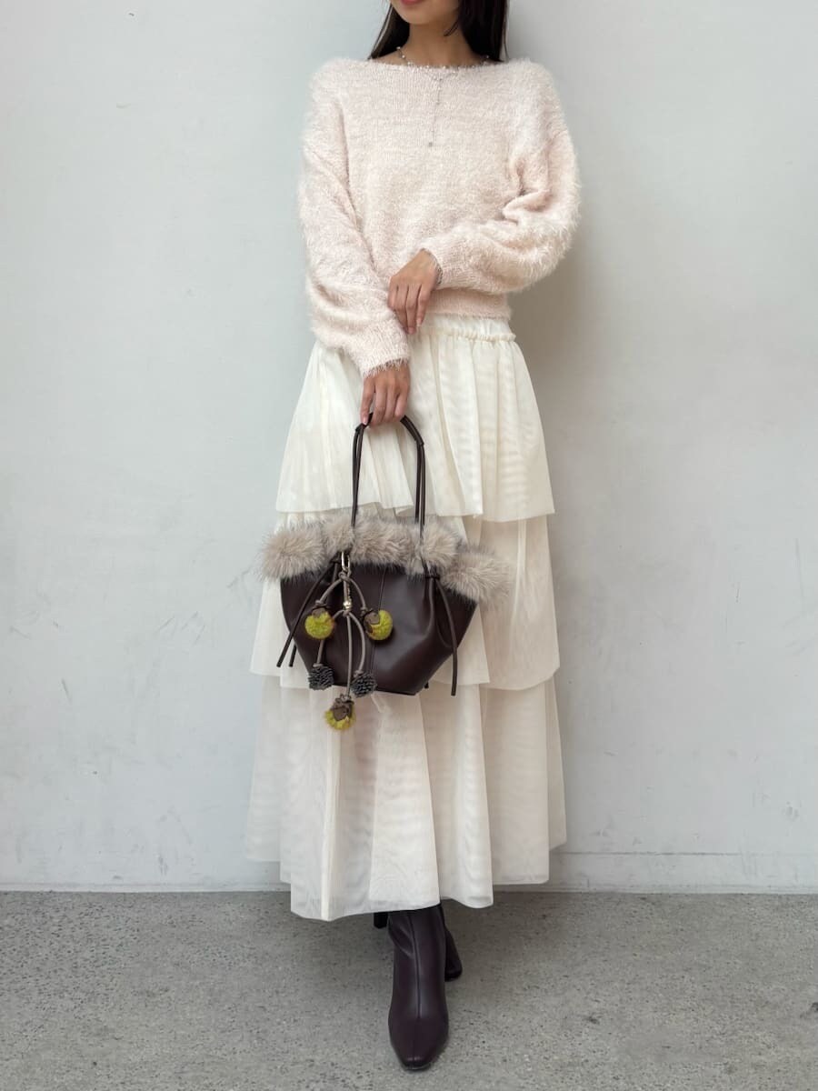 レッド系のブーツ、グレー系のチェスターコート、ホワイト系のスカートを着用したレディースの冬コーディネートの8枚目の写真