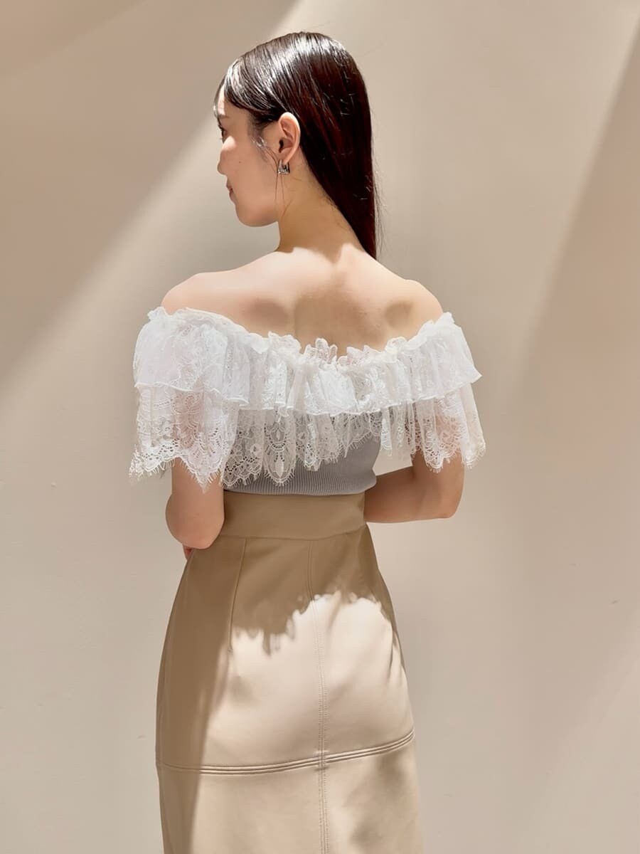 グリーン系のニット/セーター、ホワイト系のスカート、ブラック系のローファーを着用したレディースの夏コーディネートの5枚目の写真