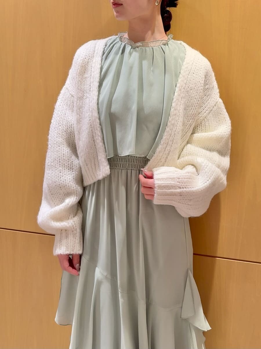 グリーン系のワンピース、ホワイト系のカーディガン/ボレロを着用したレディースの冬コーディネートの6枚目の写真