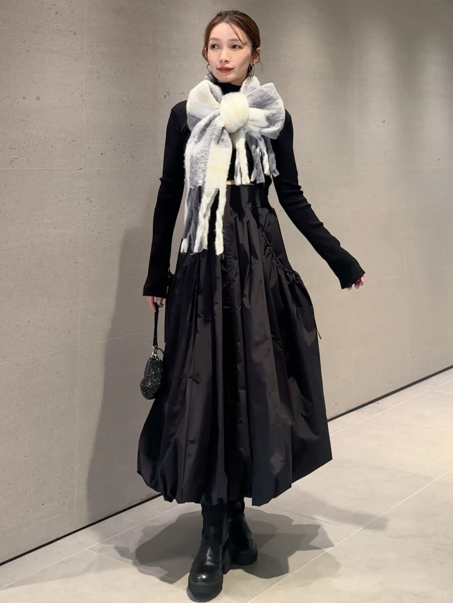 ブラック系のスカート、ブラック系のニット/セーター、グレー系のストール/ショールを着用したレディースの秋コーディネートの7枚目の写真