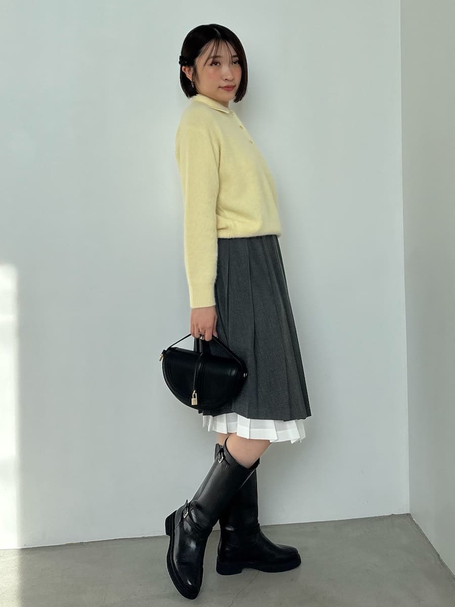 ブラック系のブーツ、ブラック系のハンドバッグ、イエロー系のニット/セーターを着用したレディースの秋コーディネートの3枚目の写真