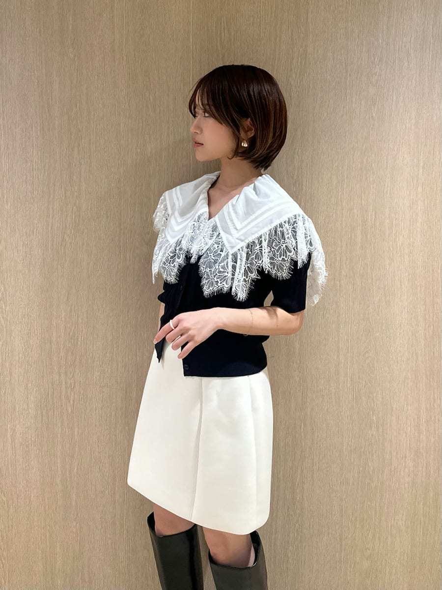 ブラック系のブーツ、ホワイト系のスカート、ブルー系のカーディガン/ボレロを着用したレディースの春コーディネートの4枚目の写真