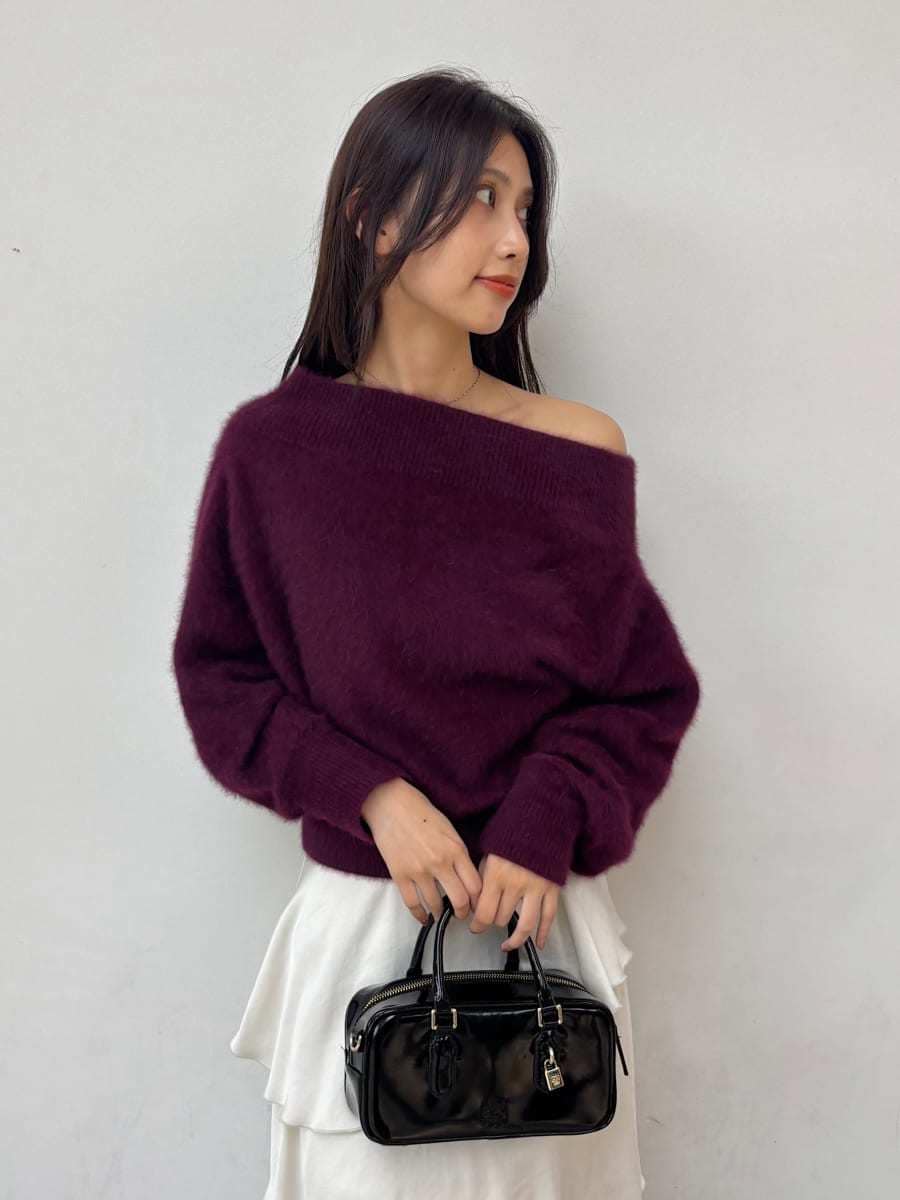 レッド系のニット/セーター、ホワイト系のスカート、グレー系のスニーカーを着用したレディースの秋コーディネートの5枚目の写真