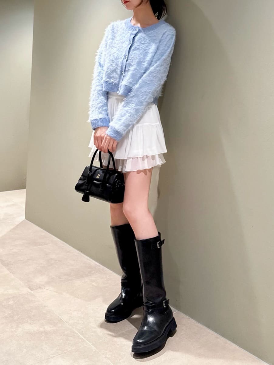 ブラック系のブーツ、ホワイト系のその他パンツ、ブルー系のカーディガン/ボレロを着用したレディースの冬コーディネートの5枚目の写真