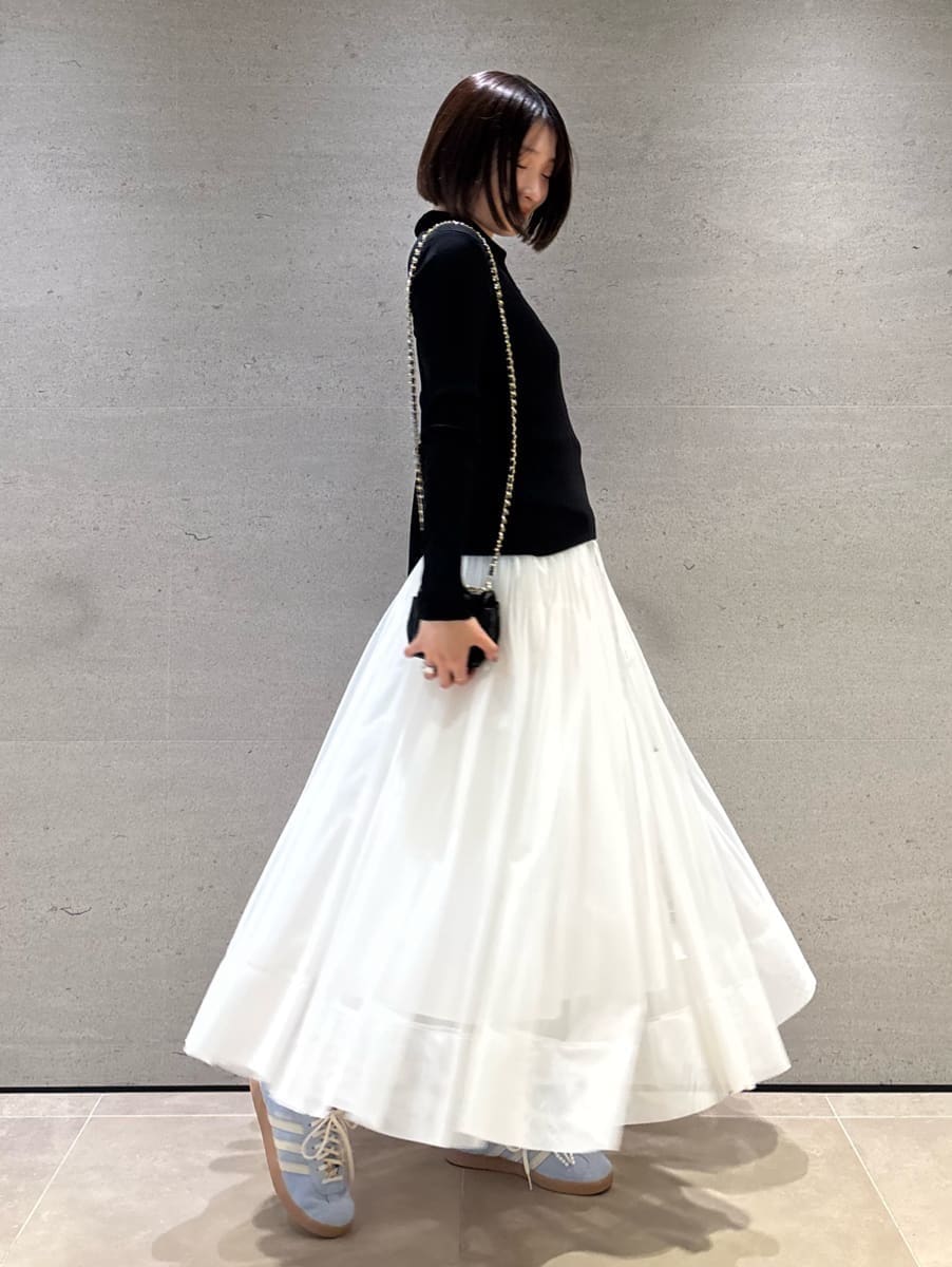 ブラック系のニット/セーター、ホワイト系のスカートを着用したレディースの秋コーディネートの3枚目の写真