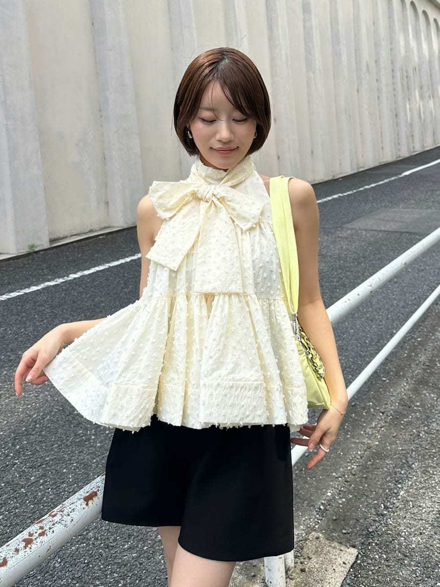 ブラック系のその他パンツ、ホワイト系のシャツ/ブラウス、イエロー系のショルダーバッグを着用したレディースの春コーディネートの3枚目の写真