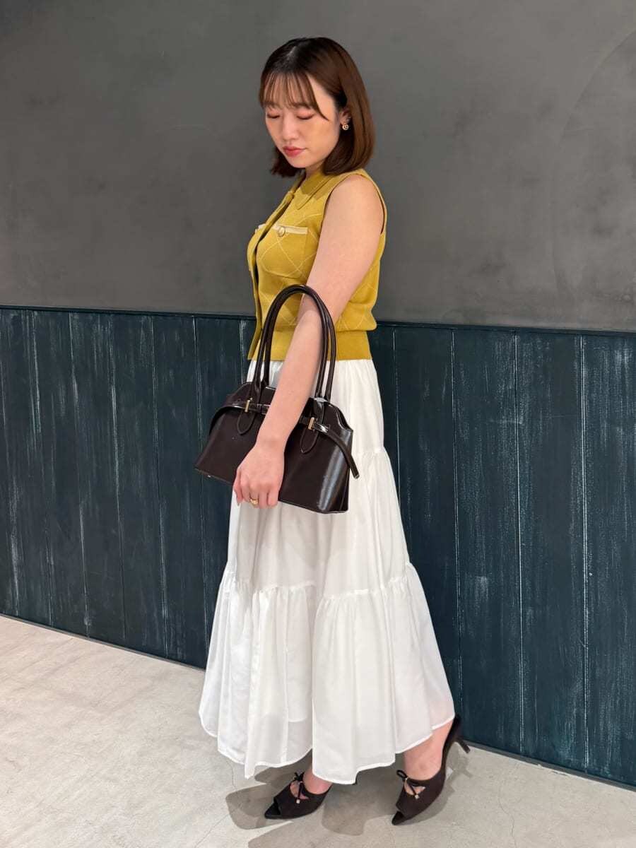 イエロー系のワンピース、ブラウン系のサンダル、ブラウン系のボストンバッグを着用したレディースの夏コーディネートの2枚目の写真