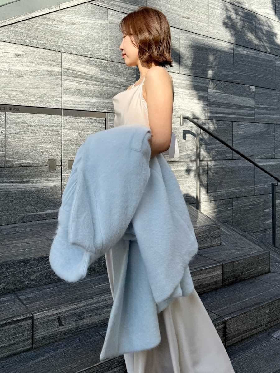 ブルー系のチェスターコート、ホワイト系のワンピースを着用したレディースの冬コーディネートの8枚目の写真