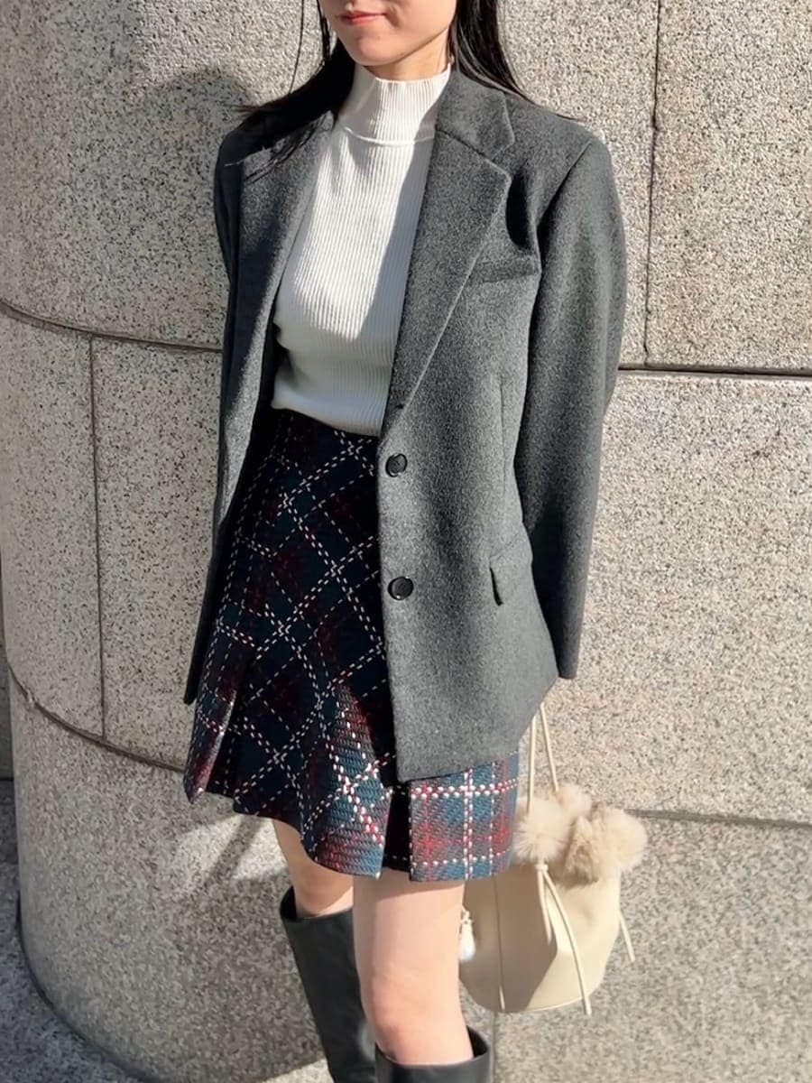 ホワイト系のニット/セーター、ブラック系のブーツ、グレー系のテーラードジャケットを着用したレディースの秋コーディネートの4枚目の写真