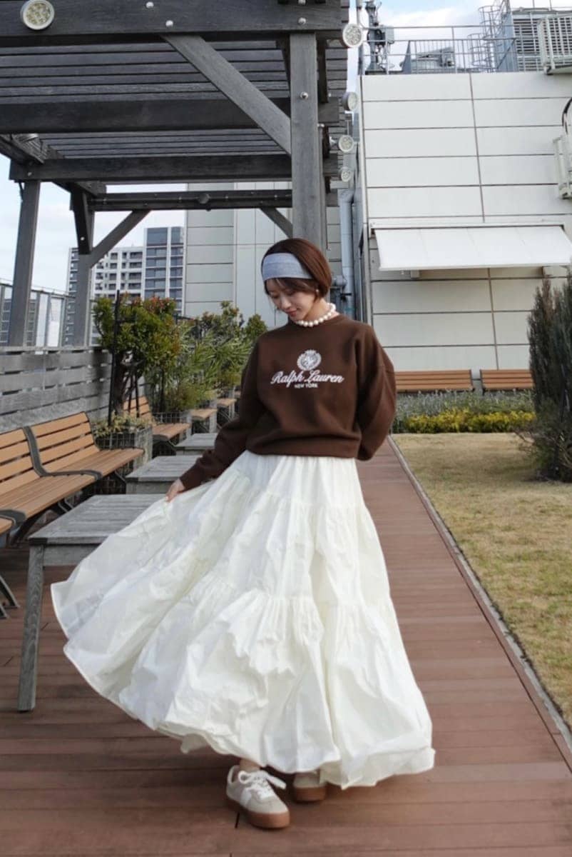 ホワイト系のスカート、ブラウン系のスウェット、ベージュ系のスニーカーを着用したレディースの春コーディネートの6枚目の写真