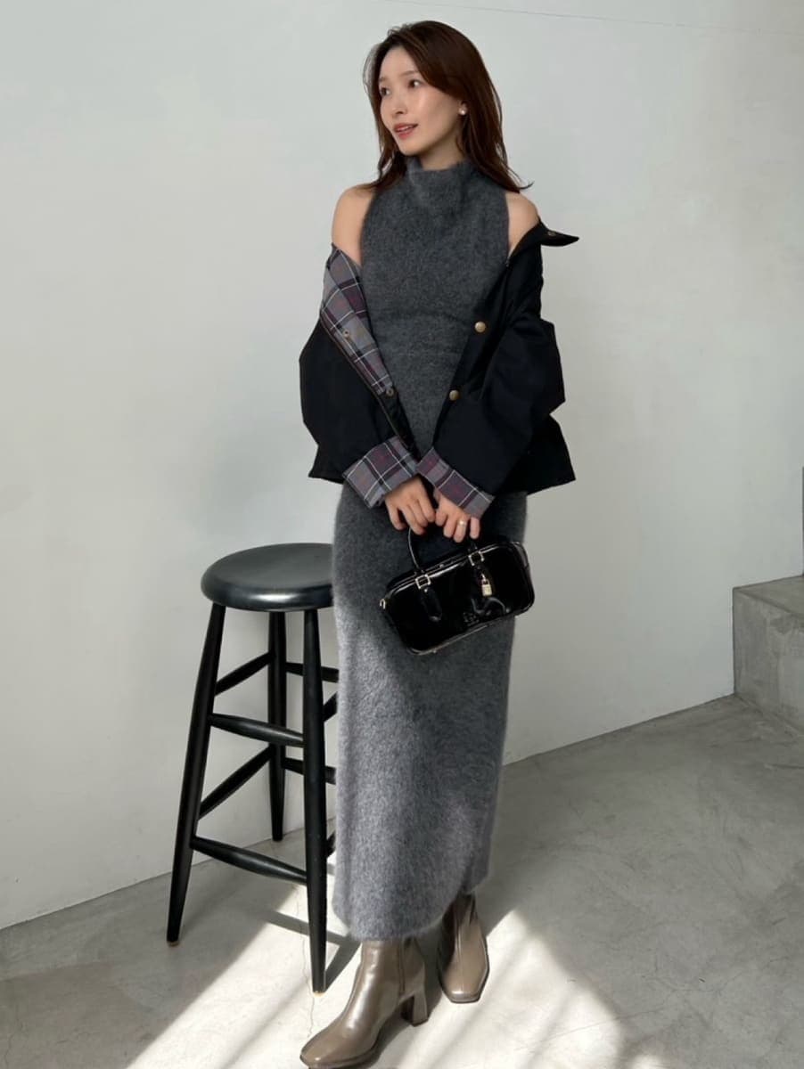 ブラック系のブルゾン、ブラック系のボストンバッグ、グレー系のワンピースを着用したレディースの秋コーディネートの2枚目の写真