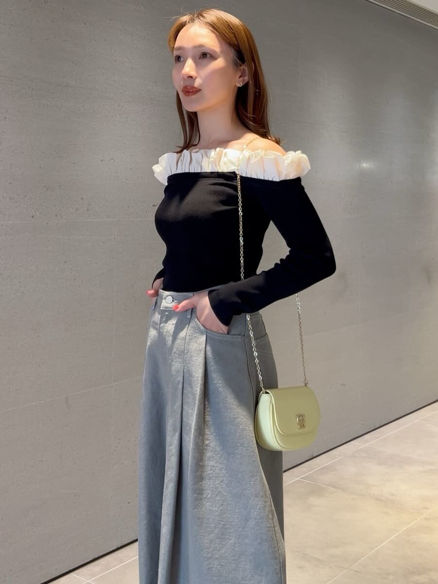 グレー系のデニムパンツ、ブラック系のニット/セーター、イエロー系のショルダーバッグを着用したレディースの冬コーディネートの3枚目の写真