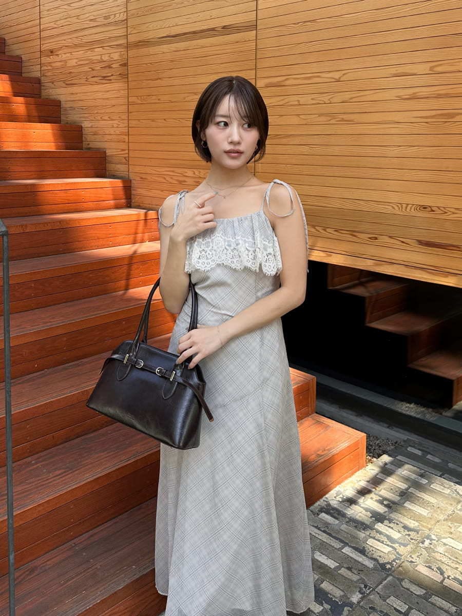 ベージュ系のワンピース、ブラウン系のブーツ、ブラウン系のボストンバッグを着用したレディースの夏コーディネートの8枚目の写真