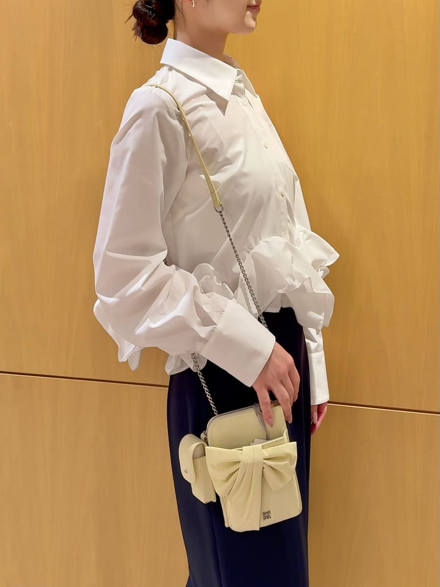 ブルー系のスカート、ホワイト系のシャツ/ブラウス、イエロー系のショルダーバッグを着用したレディースの冬コーディネートの10枚目の写真