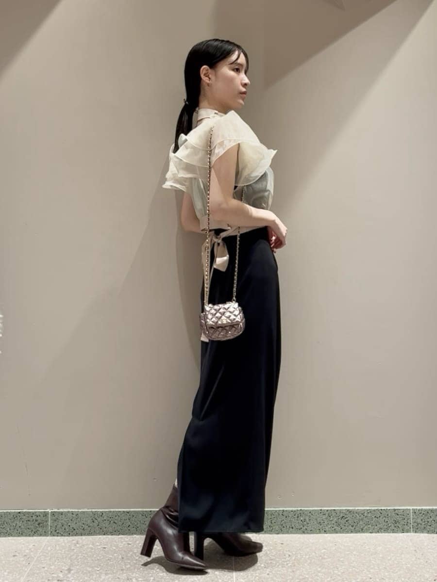 レッド系のブーツ、パープル系のショルダーバッグ、ブラック系のワンピースを着用したレディースの冬コーディネートの2枚目の写真