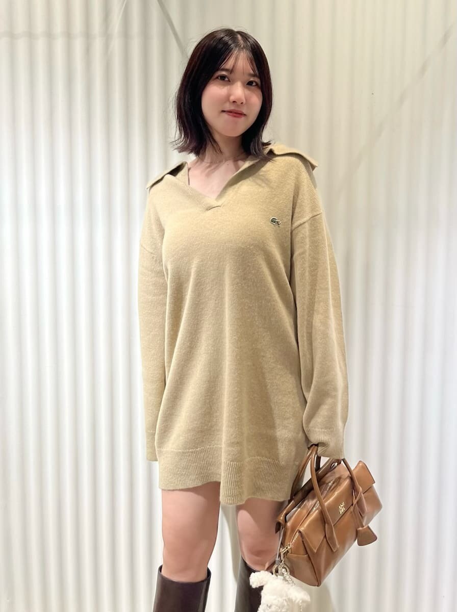 ホワイト系のダウンジャケット/コート、ブラウン系のブーツ、イエロー系のボストンバッグを着用したレディースの秋コーディネートの4枚目の写真