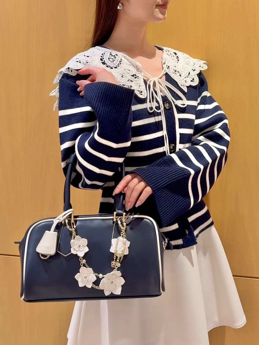 ホワイト系のその他パンツ、その他のカーディガン/ボレロ、ブルー系のボストンバッグを着用したレディースの冬コーディネートの9枚目の写真