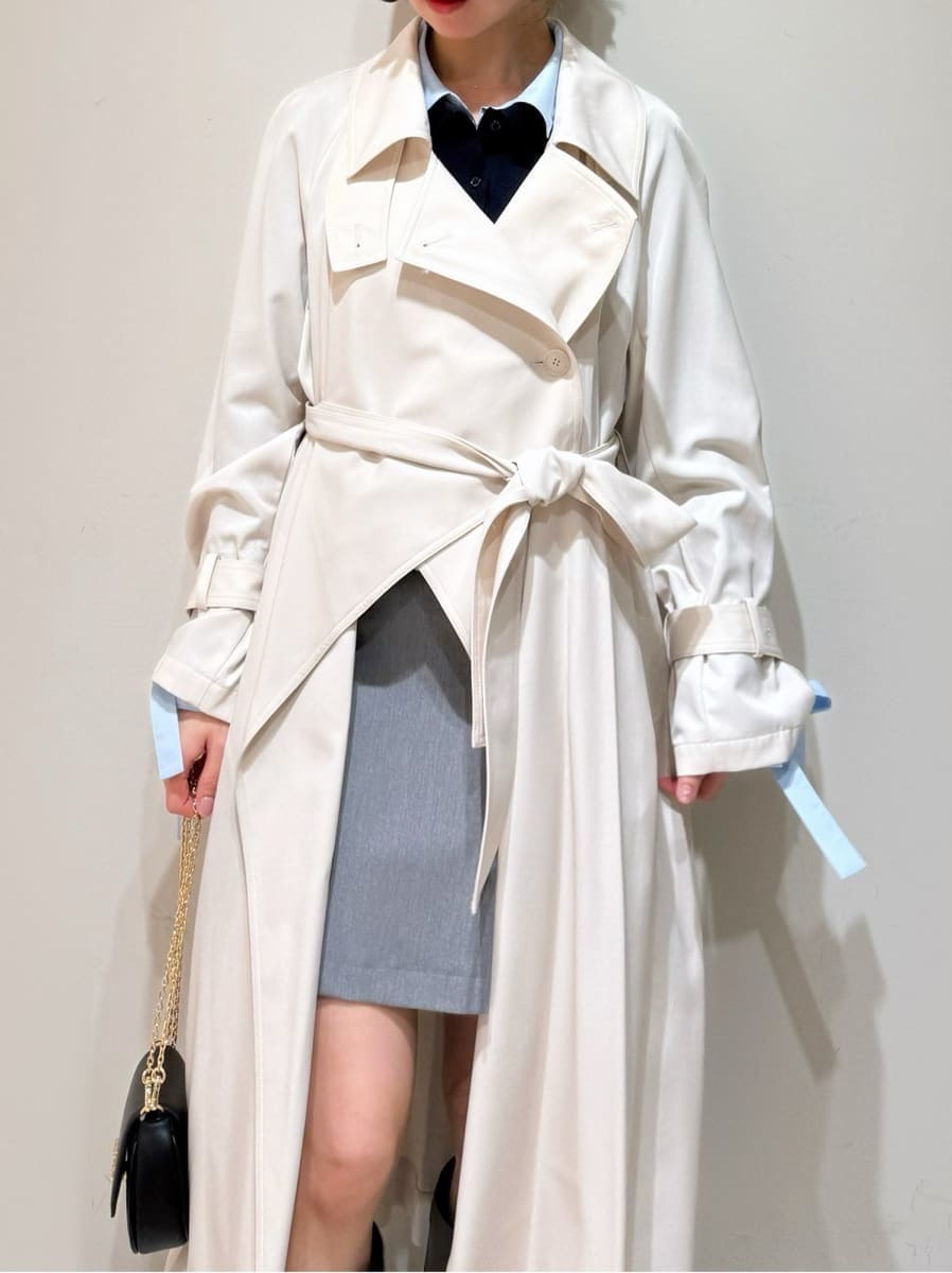 ホワイト系のトレンチコート、グレー系のスカート、ブルー系のニット/セーターを着用したレディースの冬コーディネートの3枚目の写真