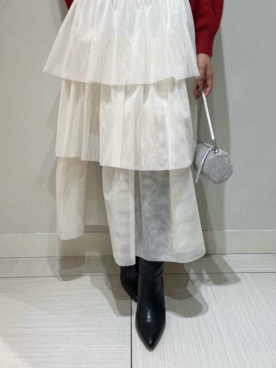 ブラック系のブーツ、ホワイト系のスカート、レッド系のカーディガン/ボレロを着用したレディースの冬コーディネートの6枚目の写真