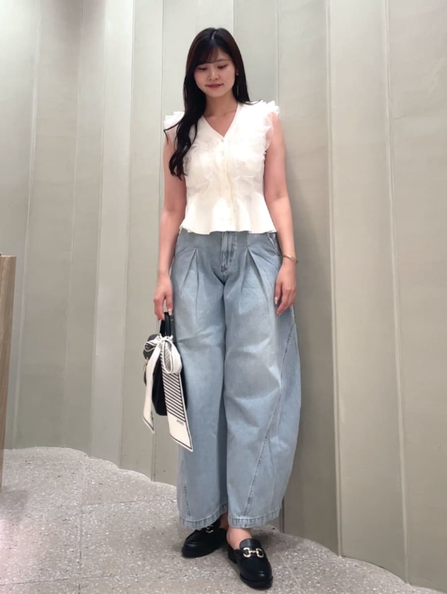 ブラック系のハンドバッグ、ブルー系のデニムパンツ、ホワイト系のニット/セーターを着用したレディースの夏コーディネートの2枚目の写真