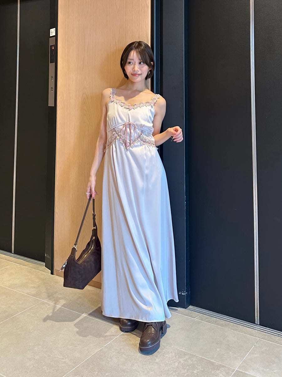 ピンク系のワンピース、ブラウン系のブーツ、ブラウン系のショルダーバッグを着用したレディースの夏コーディネートの2枚目の写真