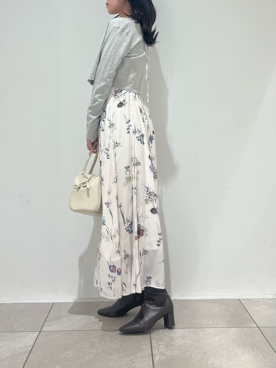 グレー系のブーツ、ホワイト系のワンピース、ホワイト系のボストンバッグを着用したレディースの冬コーディネートの2枚目の写真