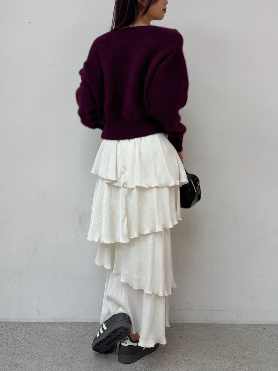レッド系のニット/セーター、ホワイト系のスカート、グレー系のスニーカーを着用したレディースの秋コーディネートの4枚目の写真
