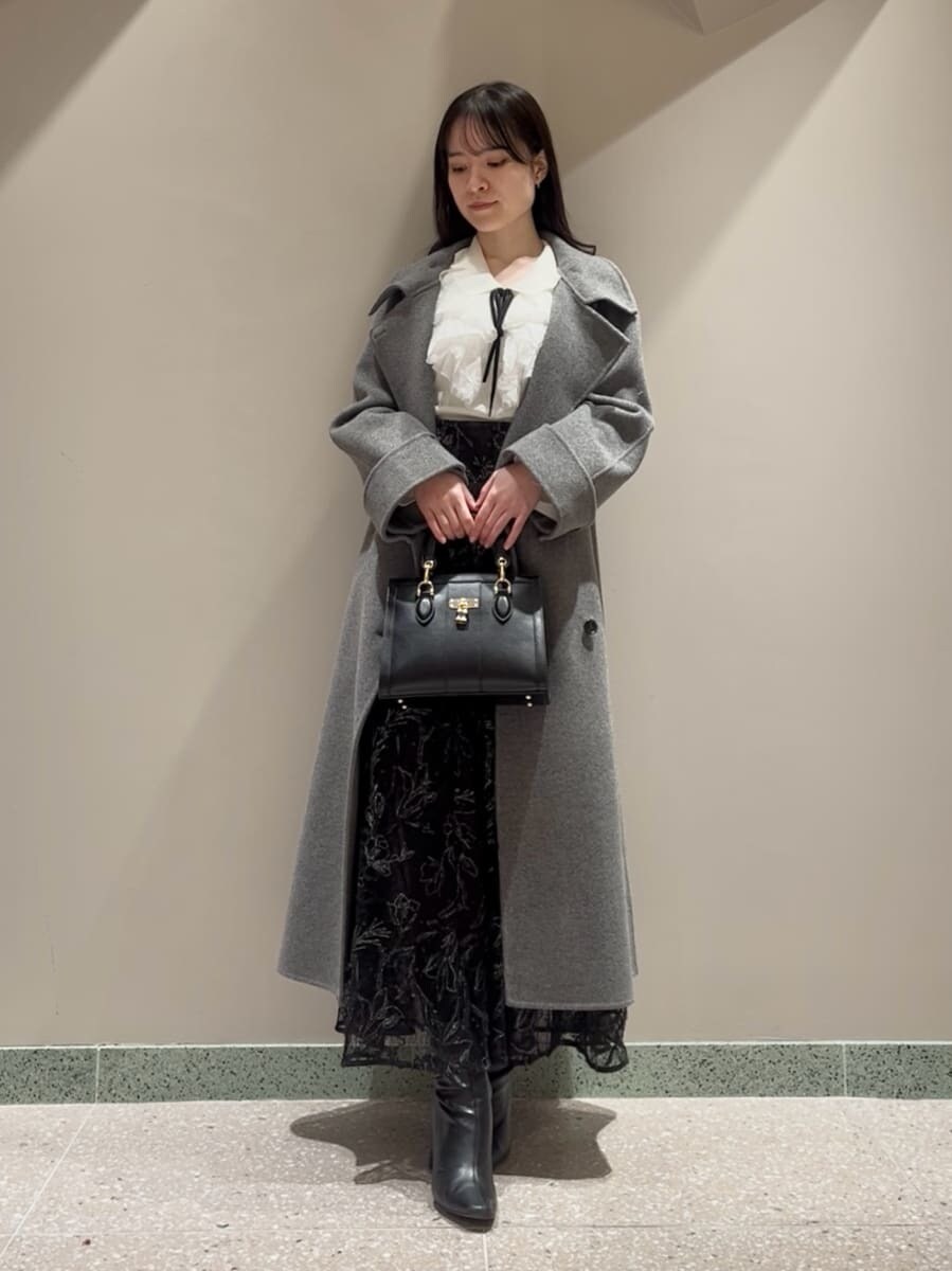 ブラック系のブーツ、グレー系のチェスターコート、ブラック系のスカートを着用したレディースの冬コーディネートの3枚目の写真