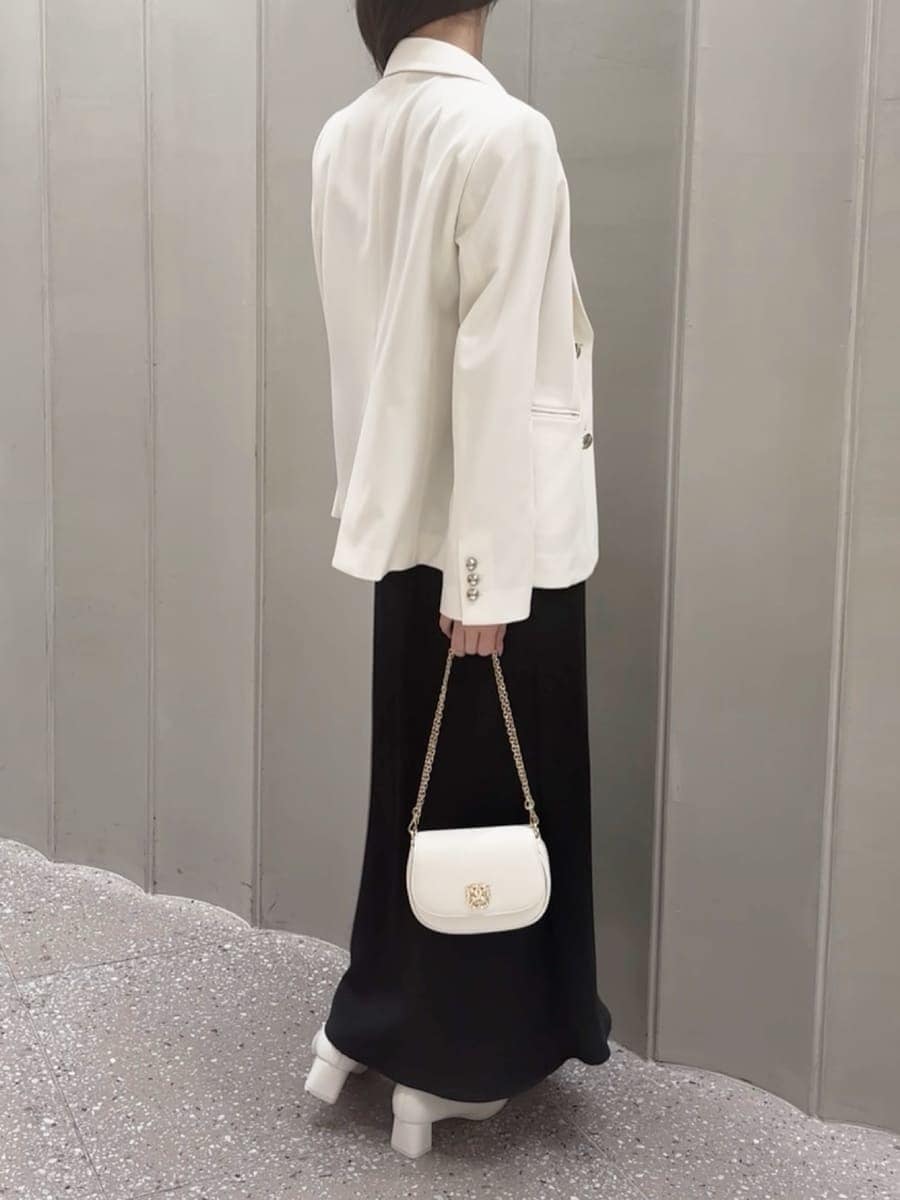 ホワイト系のテーラードジャケット、ブラック系のワンピース、ホワイト系のショルダーバッグを着用したレディースの春コーディネートの4枚目の写真