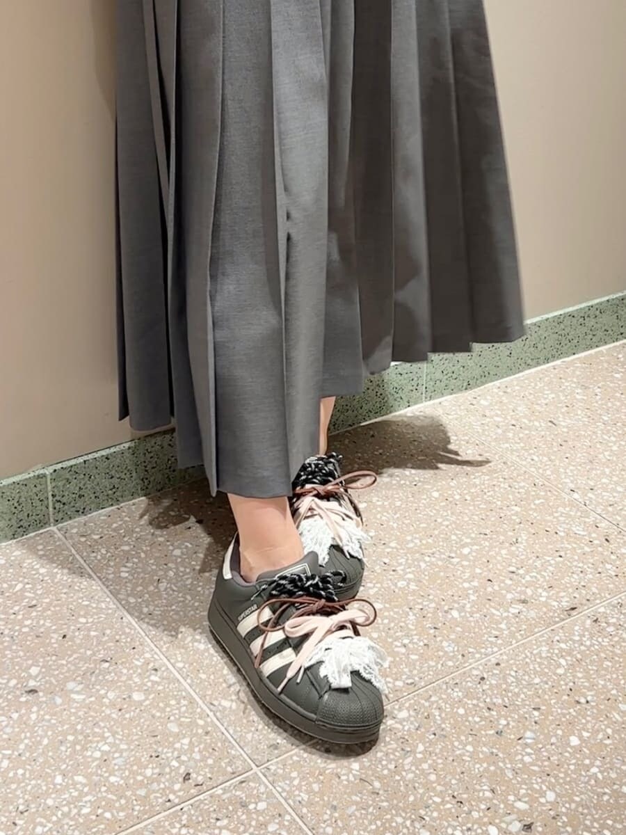 グレー系のスカート、ブラック系のボストンバッグを着用したレディースの秋コーディネートの6枚目の写真