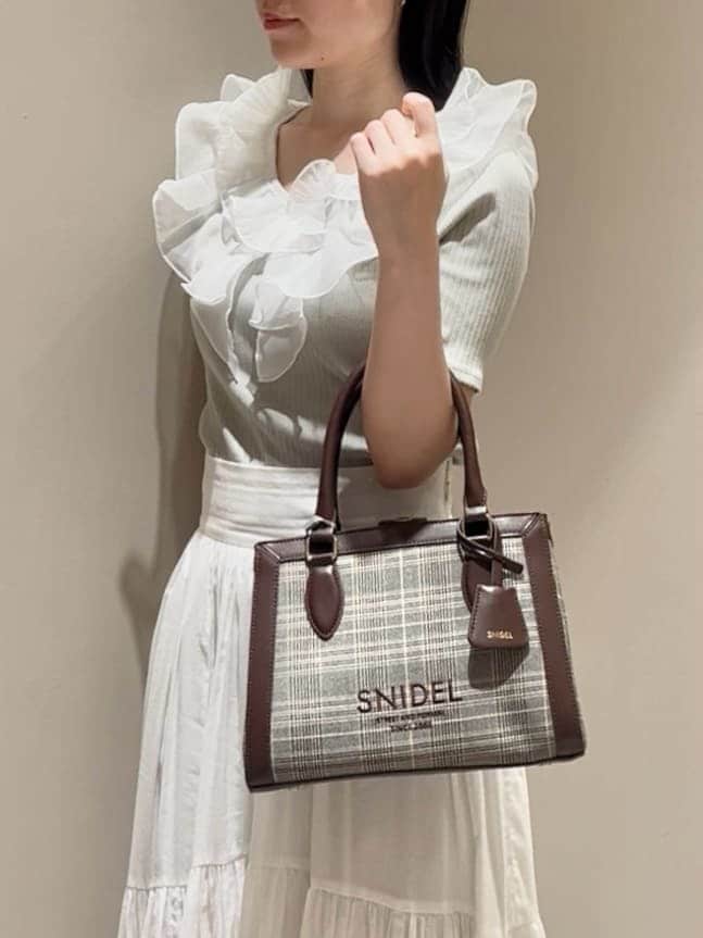 グリーン系のTシャツ/カットソー、ホワイト系のスカート、ブラウン系のハンドバッグを着用したレディースの夏コーディネートの5枚目の写真