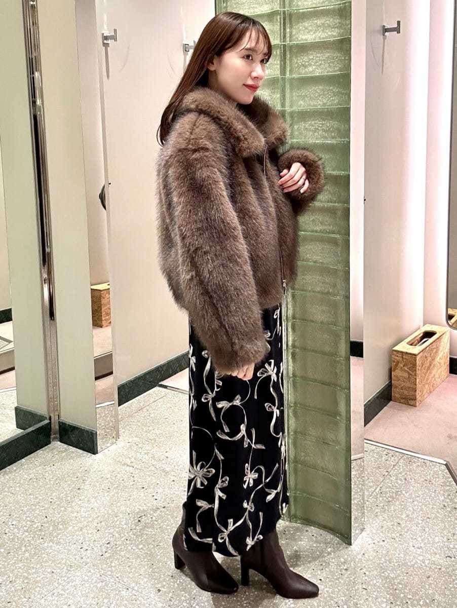 ブラウン系のチェスターコート、ブルー系のワンピース、レッド系のブーツを着用したレディースの秋コーディネートの4枚目の写真