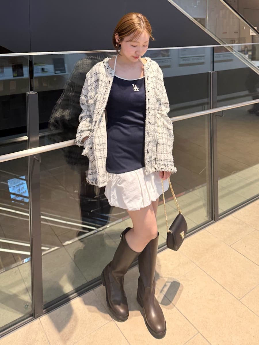 ホワイト系のノーカラージャケット、ブルー系のワンピース、ブラック系のショルダーバッグを着用したレディースの春コーディネートの3枚目の写真