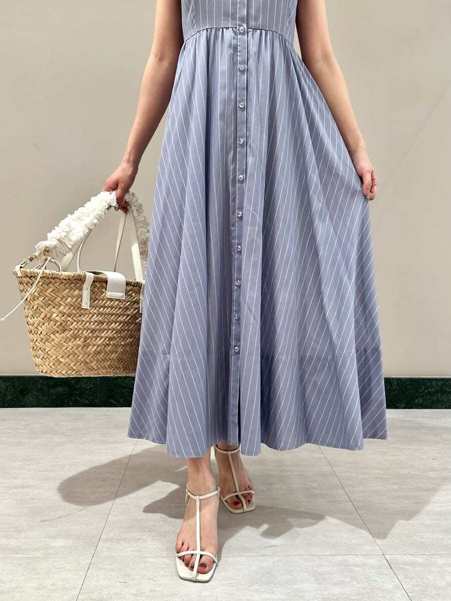 ブルー系のワンピース、ホワイト系のサンダル、ホワイト系のかごバッグを着用したレディースの夏コーディネートの5枚目の写真