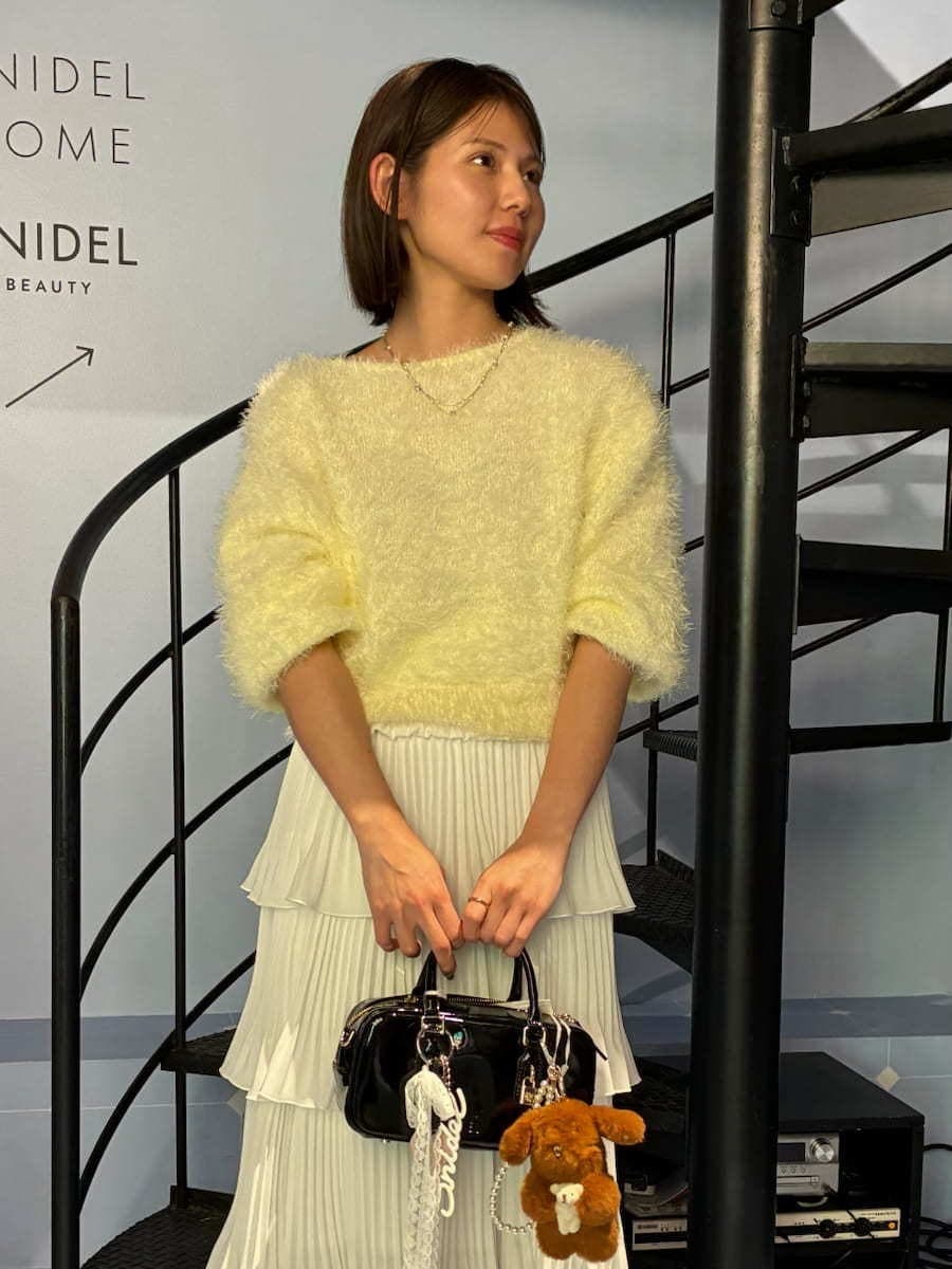 ブラック系のブーツ、ブラック系のボストンバッグ、イエロー系のニット/セーターを着用したレディースの冬コーディネートの4枚目の写真