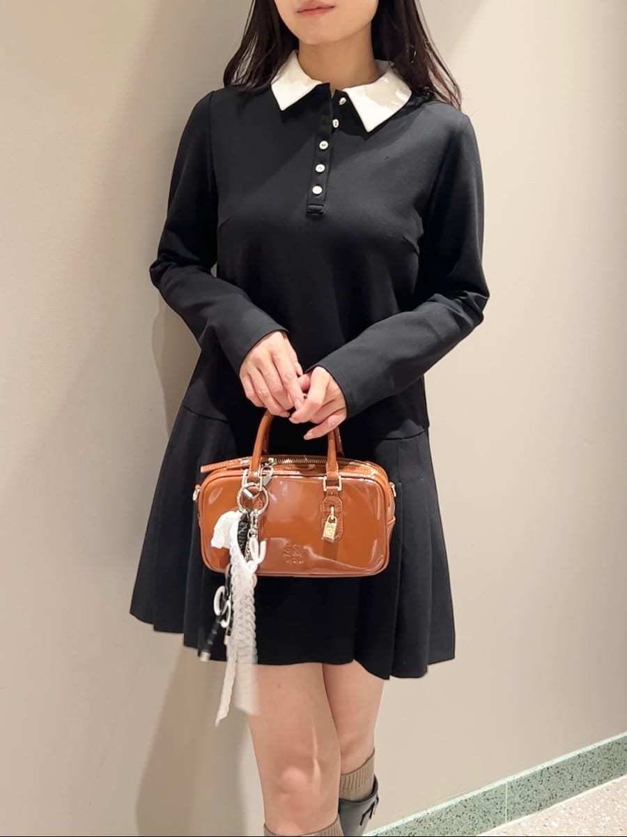 ブラック系のブルゾン、ブラック系のワンピース、ブラウン系のボストンバッグを着用したレディースの秋コーディネートの5枚目の写真