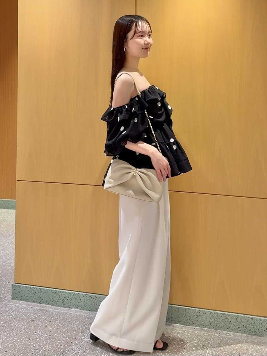 ホワイト系のその他パンツ、ブラック系のシャツ/ブラウス、ブラック系のサンダルを着用したレディースの春コーディネートの2枚目の写真