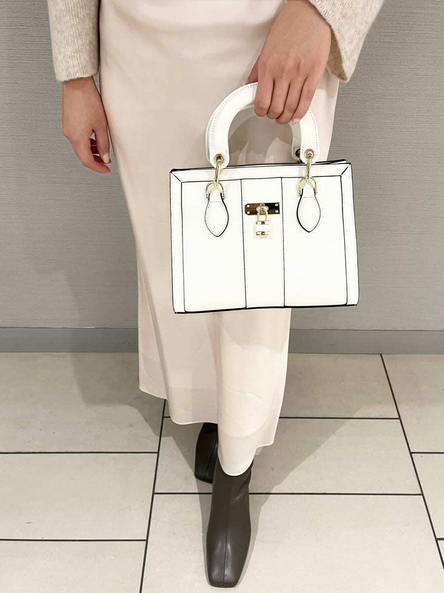 ピンク系のワンピース、ホワイト系のハンドバッグを着用したレディースの冬コーディネートの4枚目の写真